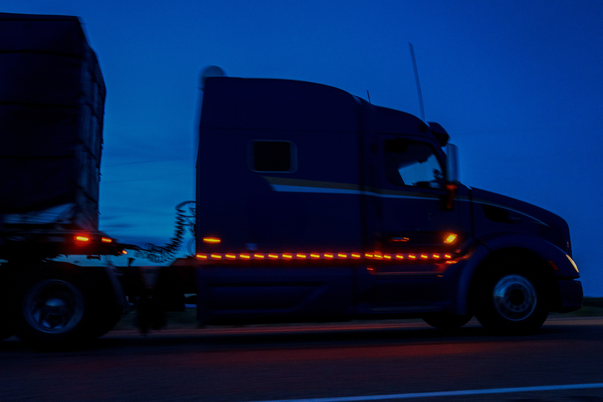 A Semi Trailer Truck Driving Down The Highway In Colorado At Night